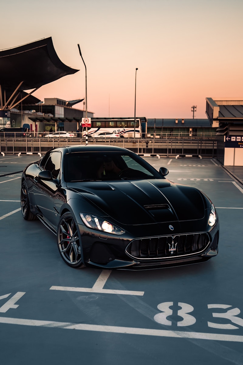 a black sports car with a good auto premium parked on a road with a building in the background